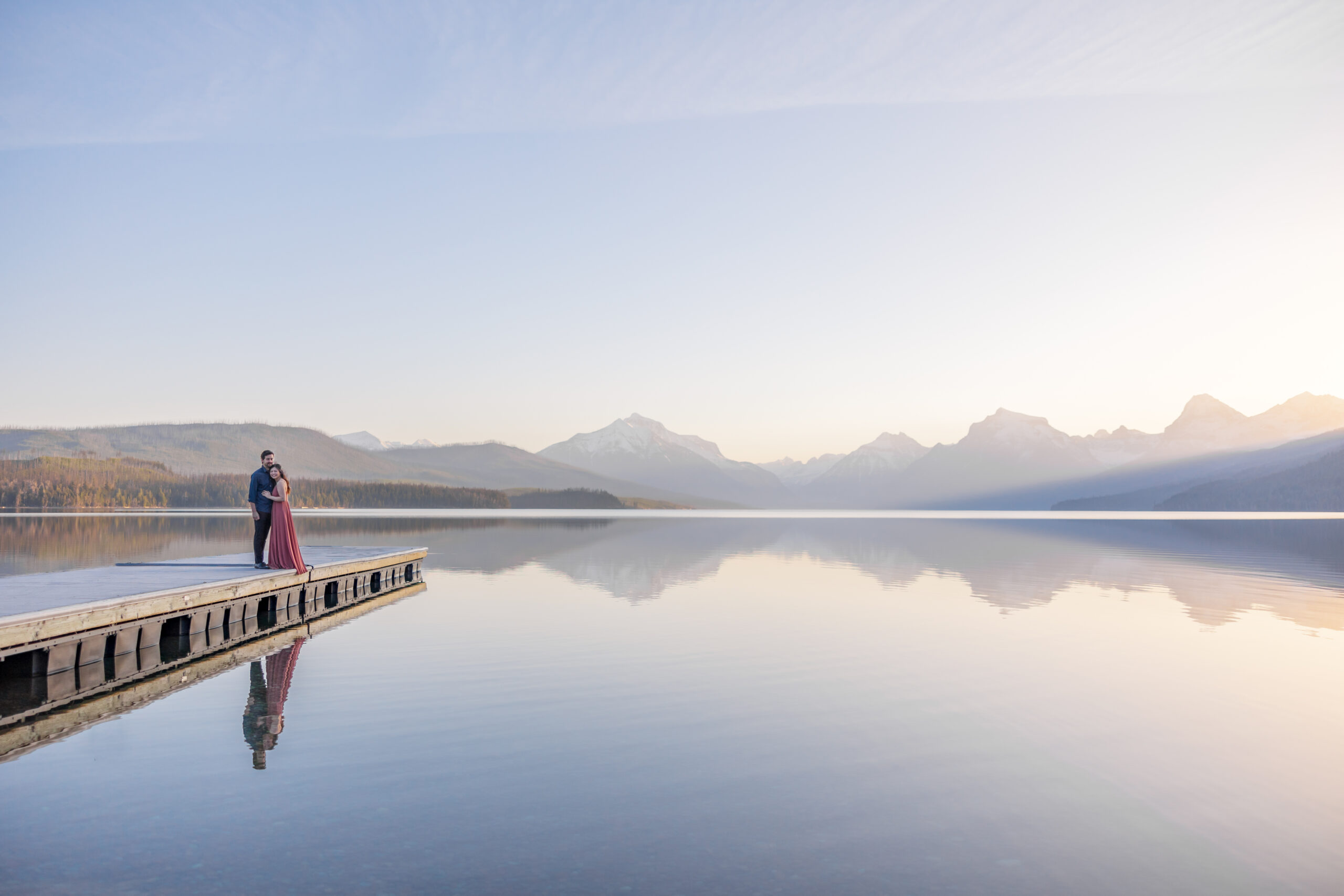 Couple stand over lake McDonald at Glacier National Park